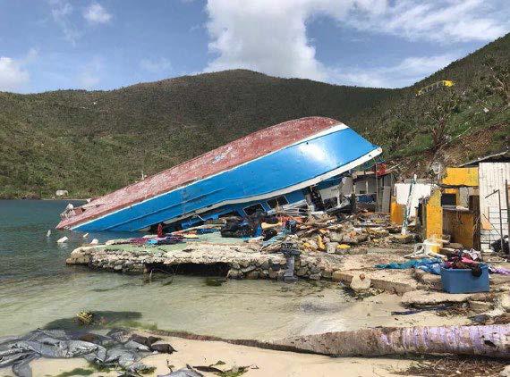 A ship lies upturned on the beach
